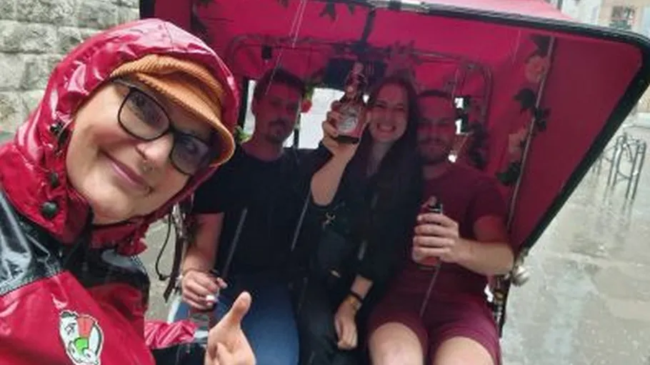 People in rickshaw smiling in the rain.