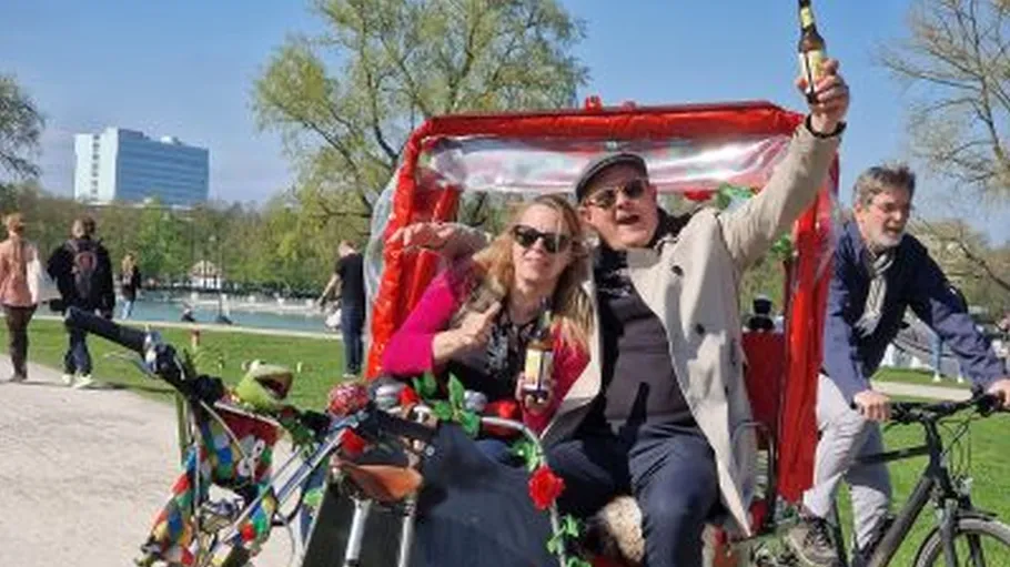 Two people celebrate in a rickshaw outdoors.