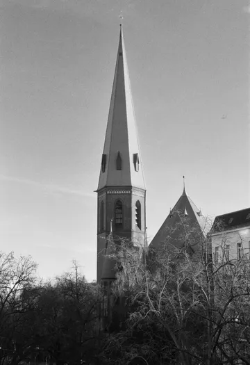 Hoher Kirchturm vor klarem Himmel.