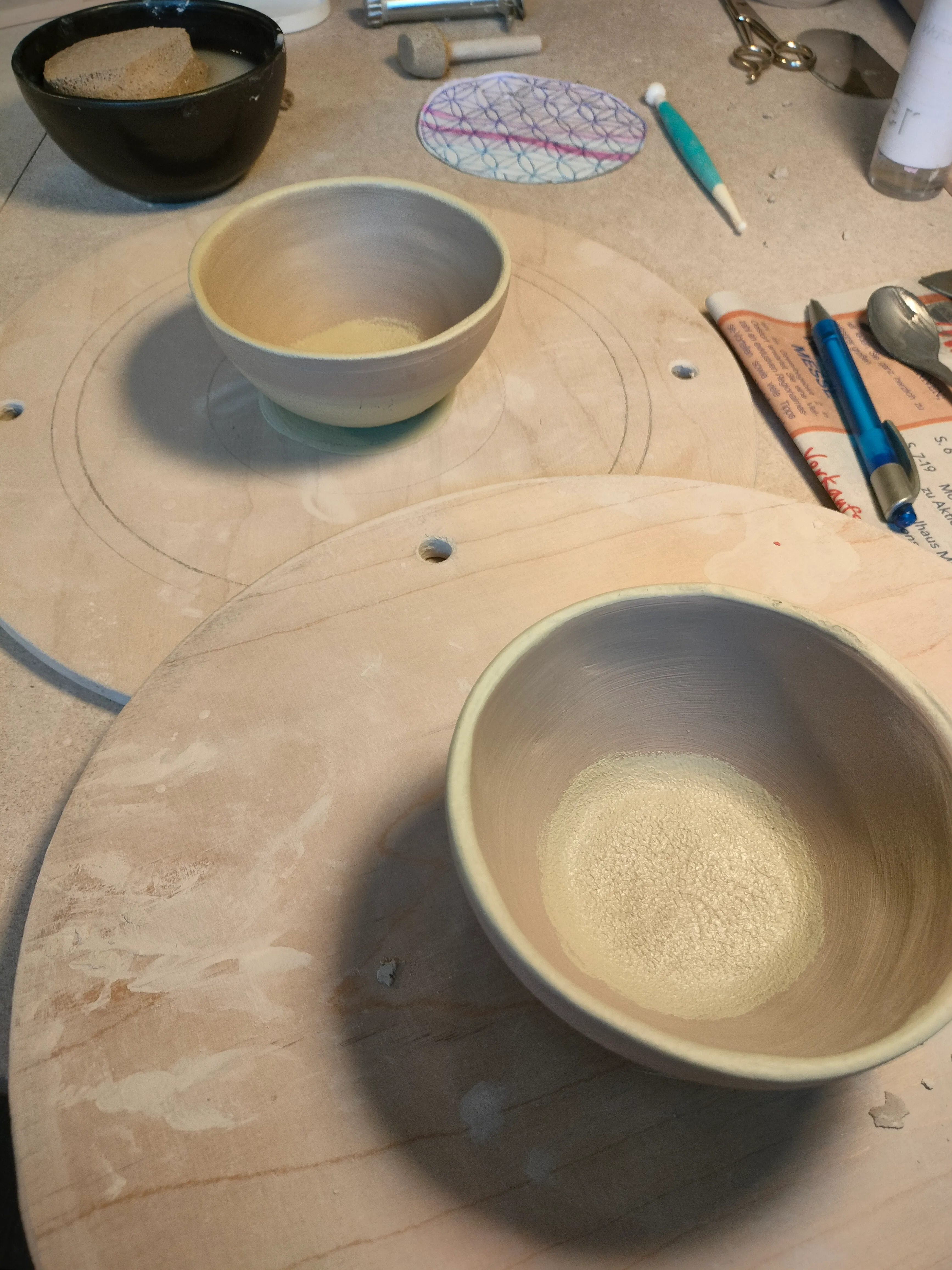 Ton-Schalen auf einer Werkbank in Arbeit.