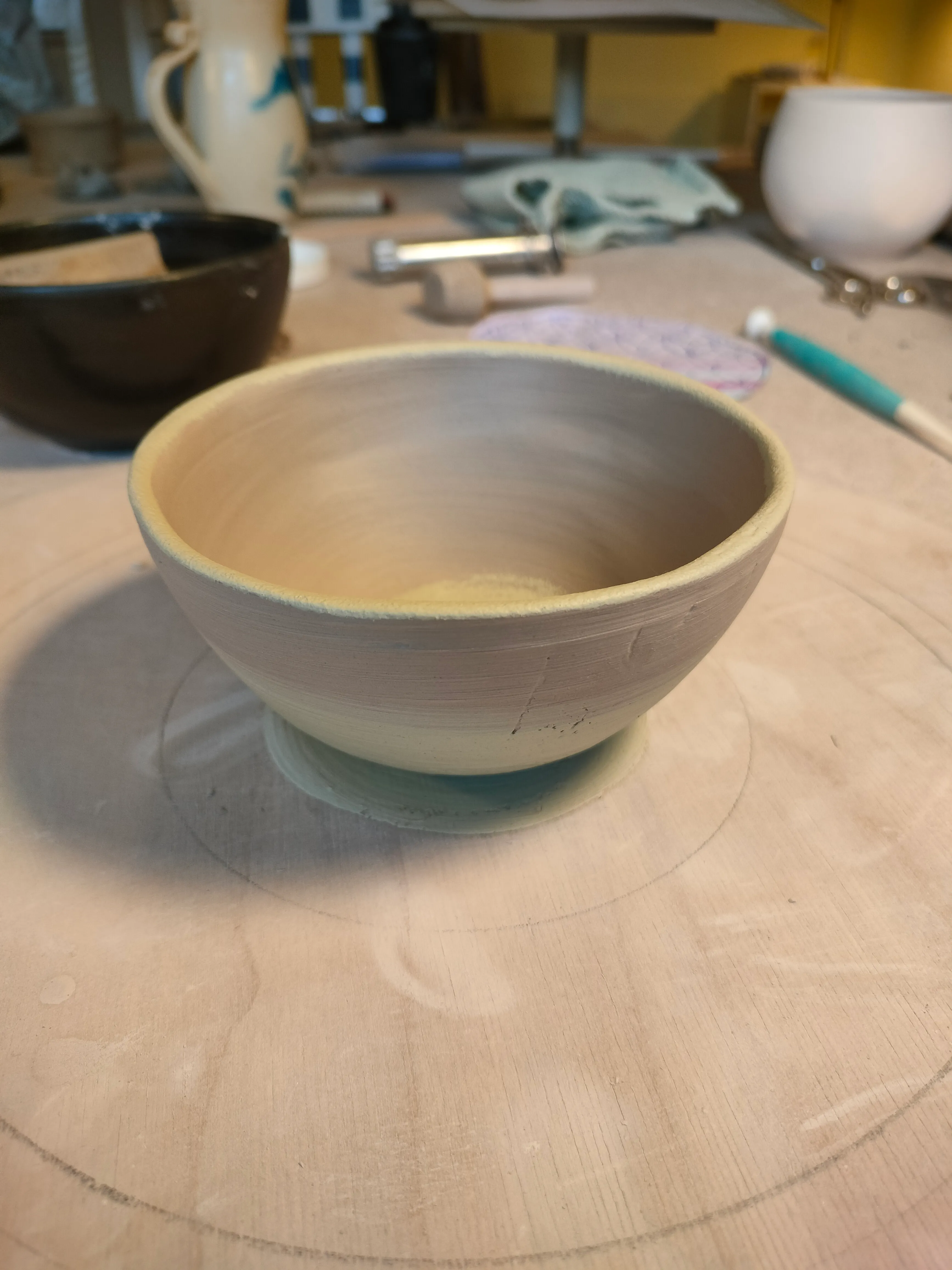 Unvollendete Tonschale auf einer Töpferscheibe.