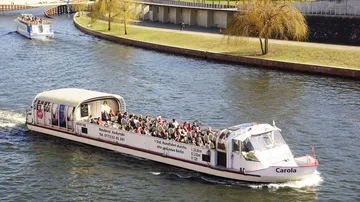 Touristenboot mit Passagieren auf einem Fluss.
