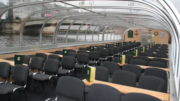 Empty boat interior with rows of chairs.