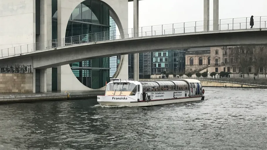 Boat named Franziska under urban bridge.
