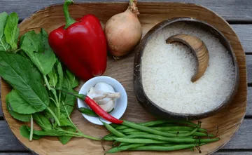 Vegetables and rice are ready on a wooden tray.