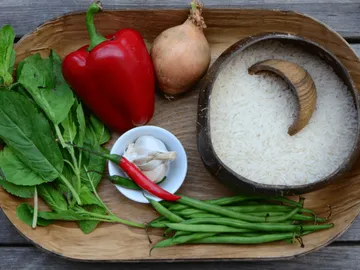 Vegetables and rice are ready on a wooden tray.