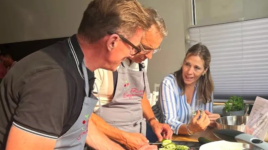 Three people discussing cooking in a kitchen.