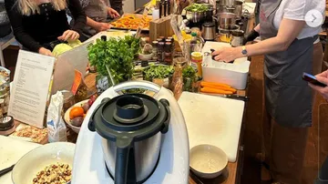 Geschäftige Küche mit Menschen beim Kochen.