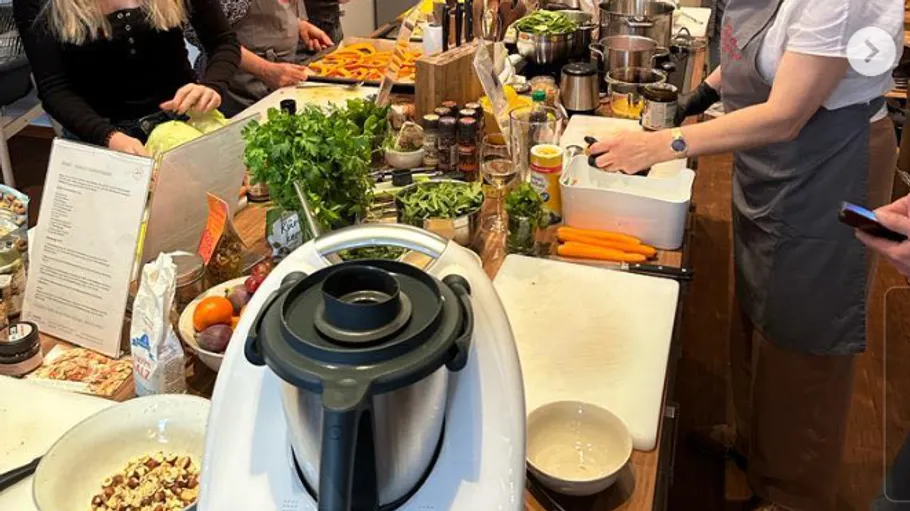 Geschäftige Küche mit Menschen beim Kochen.