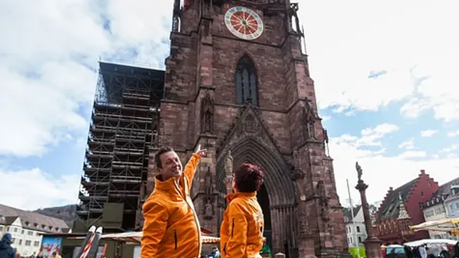 Two people pointing at historic church exterior.