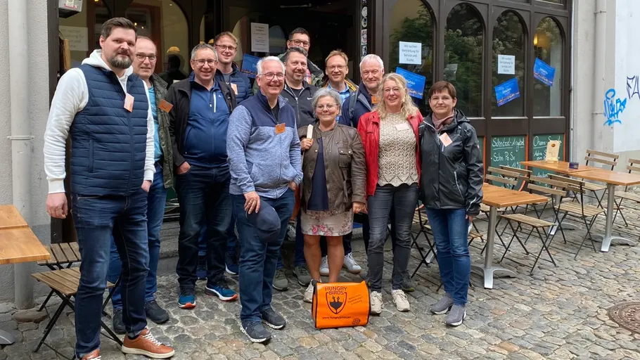 Group of people standing outside a cafe.