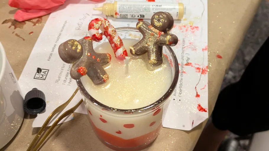 Dekorierte Weihnachtskerze mit Lebkuchenfiguren.