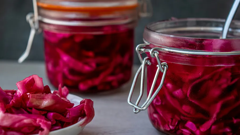 Jars of pickled red cabbage on table.