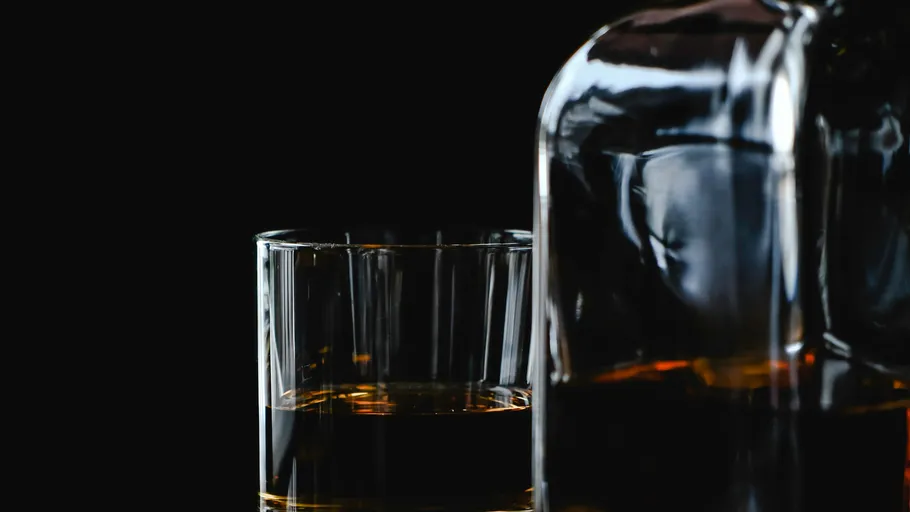 Whiskeyglas neben einer Flasche.