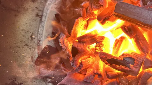 Glowing embers burning in a fire pit.