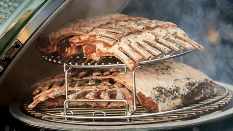 Ribs smoking in a green ceramic grill.
