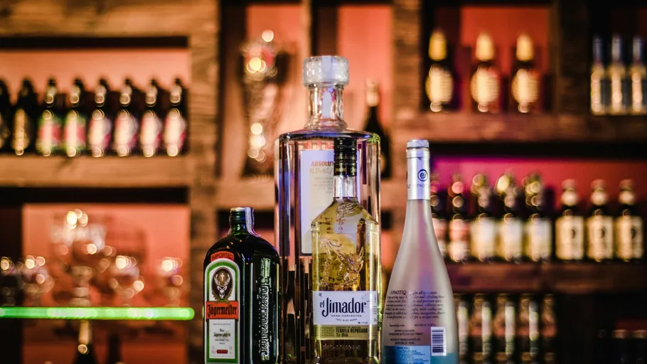 Liquor bottles displayed on a bar shelf.