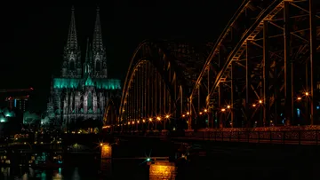 Kathedrale und Brücke nachts beleuchtet.