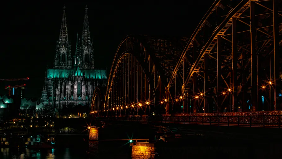Cathedral and bridge illuminated at night.