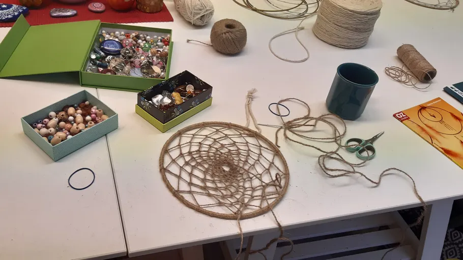 Craft supplies and dreamcatcher on table.