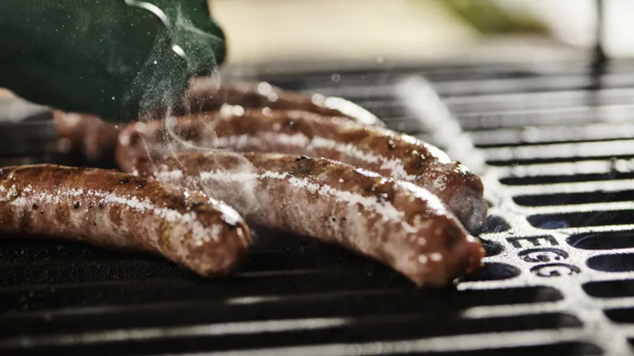 Würste auf einem Metallgrill gebraten.