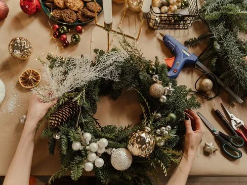 Wreath is decorated with ornaments and tools on the table.