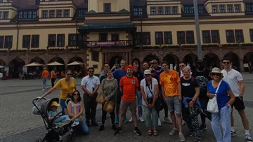 Gruppe von Menschen vor historischem Gebäude posierend.