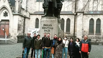 Gruppe posiert bei Johann-Sebastian-Bach-Statue.