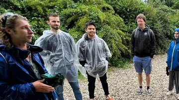 Gruppe von Leuten trägt Regenmäntel im Freien.