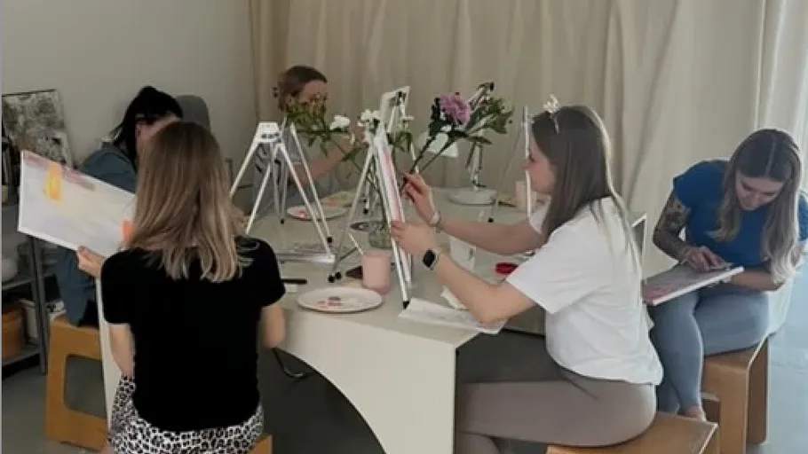 Group of women painting in a cozy room.