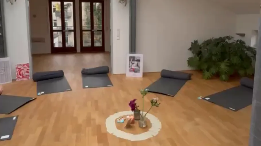 Yogamatten im Kreis auf Holzboden arrangiert.