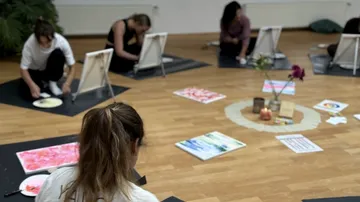 People painting on mats in an art studio.