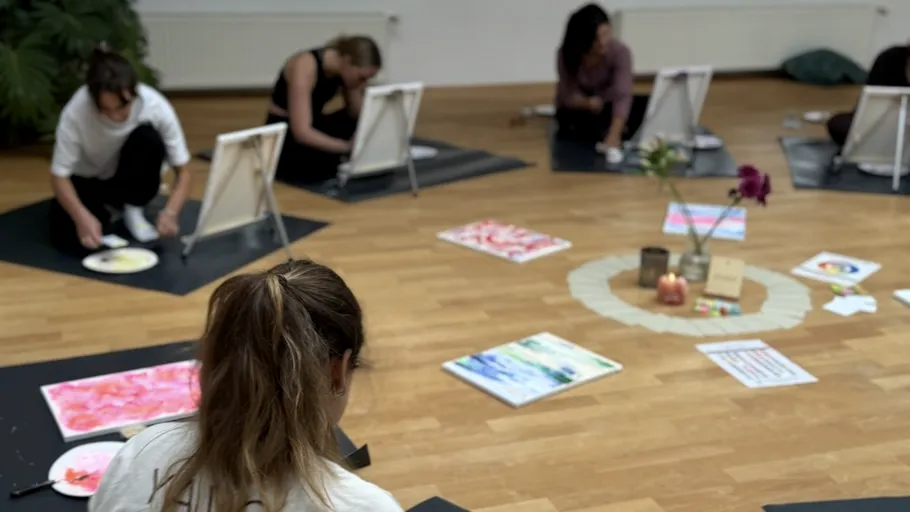 Menschen malen auf Matten in einem Kunststudio.