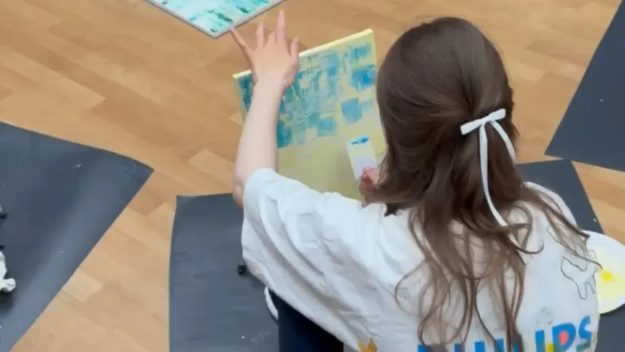 Person painting on canvas indoors.