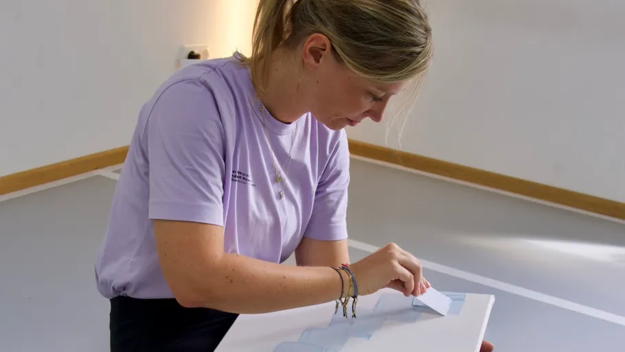 Person painting on a canvas indoors.