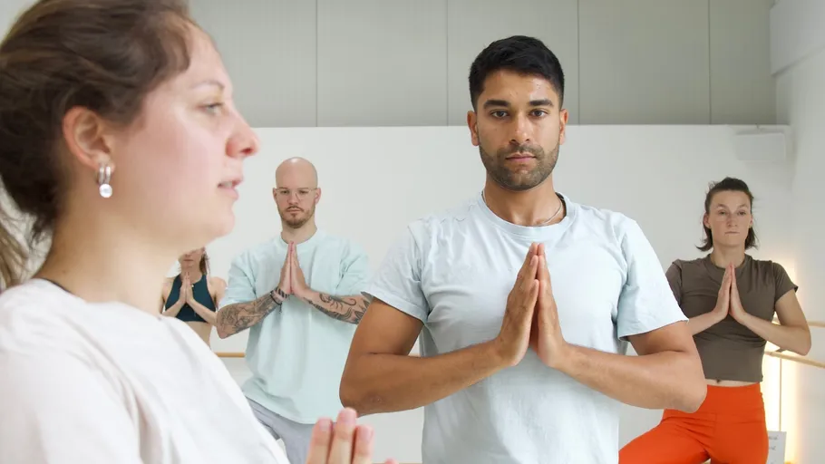 People practicing yoga in a white room.