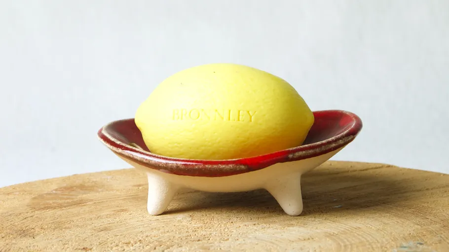 Yellow soap shaped as lemon on dish.