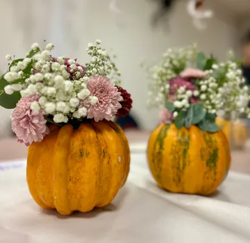 Kürbisse als Vasen mit Blumen gefüllt.