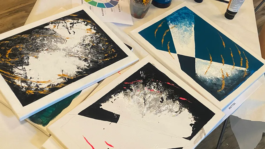 Abstract paintings on table with paint tools.