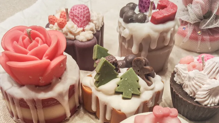 Dekorative Kerzen in Kuchenform auf Tisch.