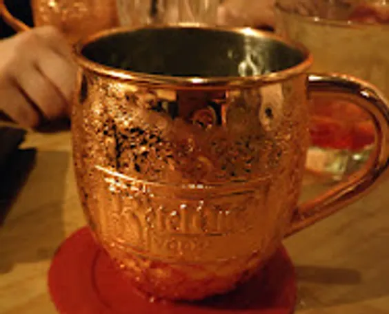 Kupferbecher auf Tisch mit Kondensation.