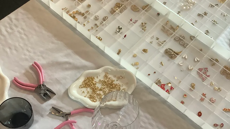 Schmuckherstellungswerkzeuge und -materialien auf einem Tisch.