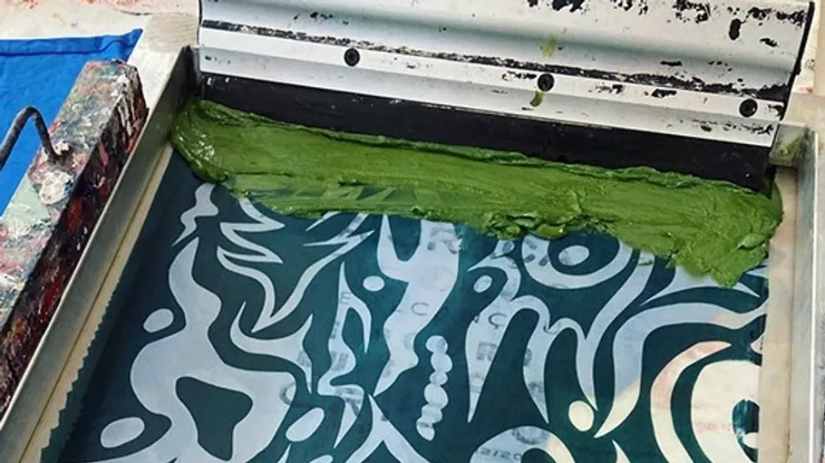 Screen printing with green ink on patterned material.