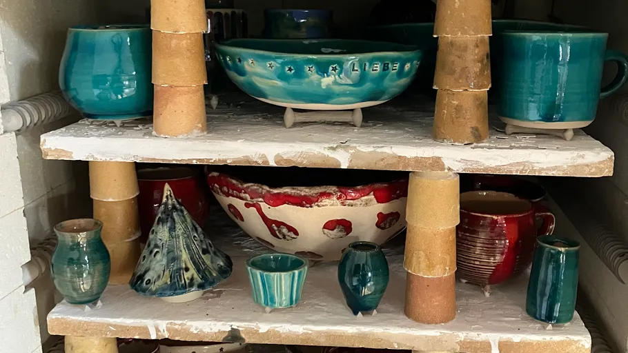 Colorful ceramic pots and bowls in a kiln.