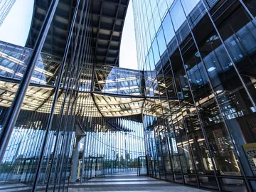The glass façade reflects light in a modern architectural environment.