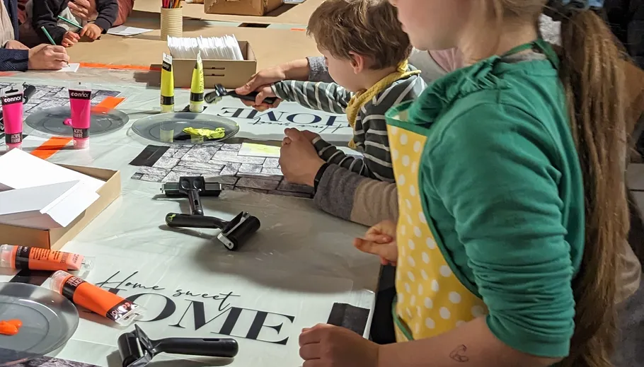 Children crafting at a table with paints.