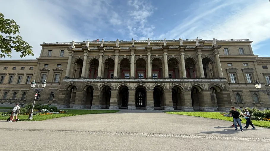 Historic building with arched entrance, people nearby.