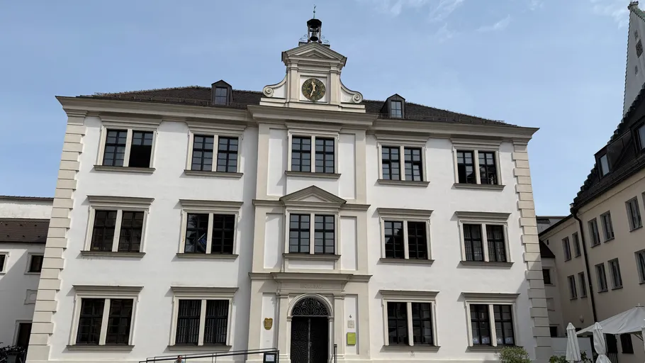 Historisches weißes Gebäude mit Uhrfassade.