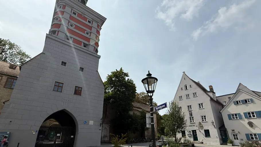 Hoher Turm neben traditionellen deutschen Gebäuden.