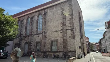 Old stone building beside urban street.